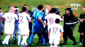 Nacional goalkeeper Jorge Bava surprises security officer with a blow.