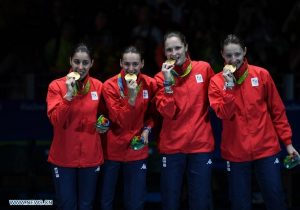 Romanian women's epee team biting their gold medals at 2016 Rio Olympics